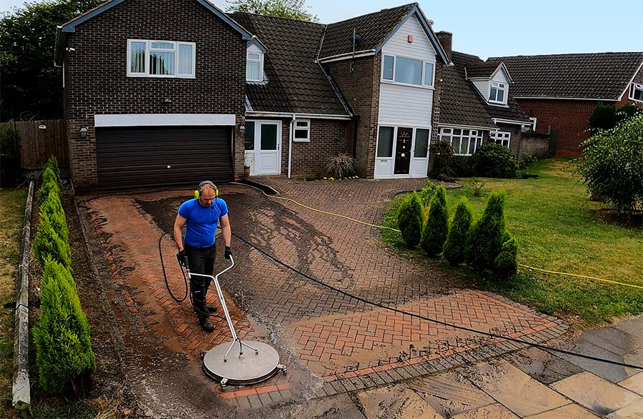 Pressure washing a paved driveway
